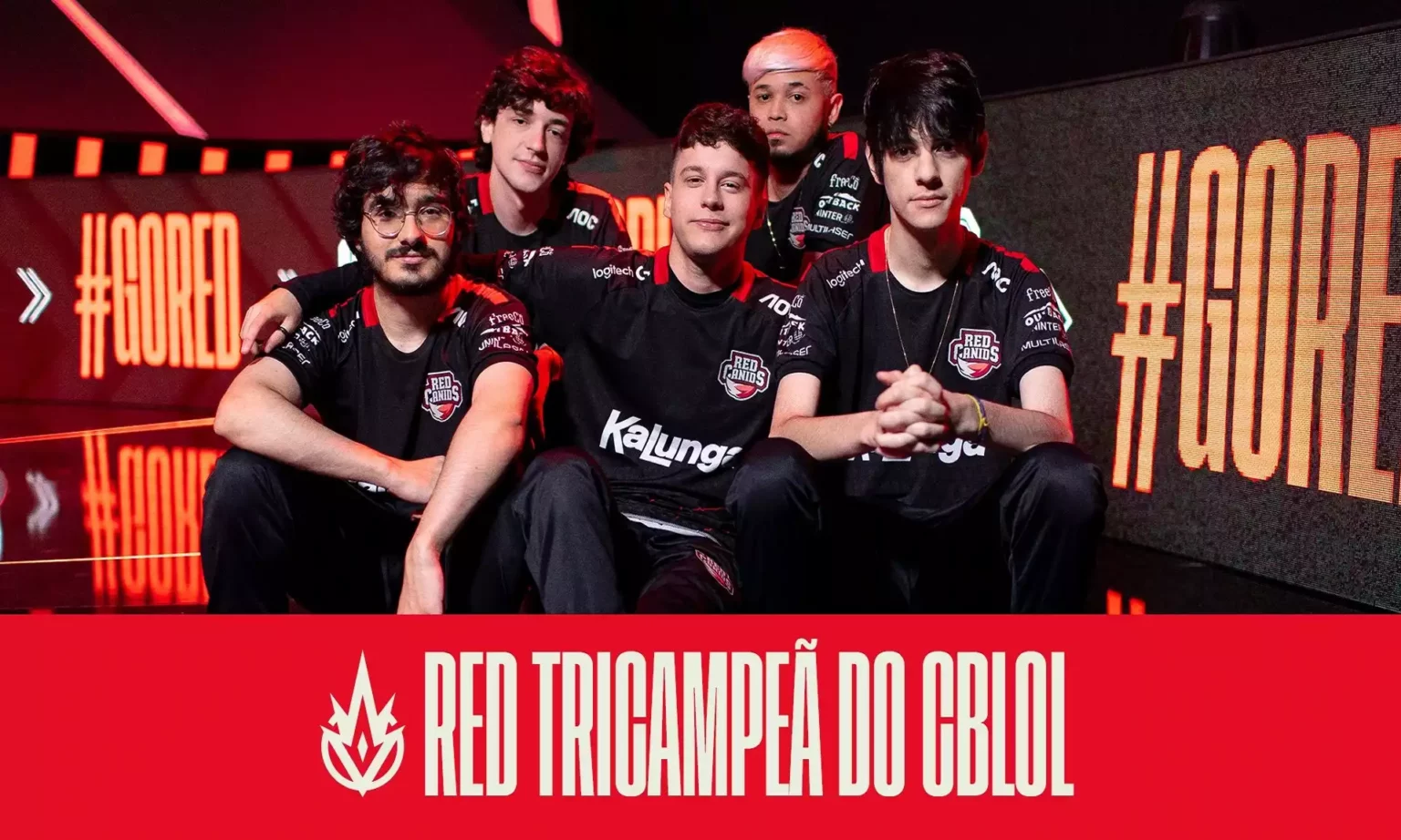 Jogadores da RED Canids Kalunga posando após conquistarem título, estando, da esquerda para direita, Guigo, Jojo, Grevthar, TitaN e Aegis. Na frente deles uma faixa diz que a equipe foi campeã