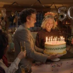 Cena do longa Aqui, com 7 pessoas ao redor de um bolo.