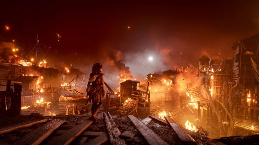 Estudio de 'A Plague Tale' prioriza criatividade humana e rejeita inteligência artificial em novo jogo 2 Mulher observa de costas uma vila costeira em chamas sob o céu noturno A Plague Tale